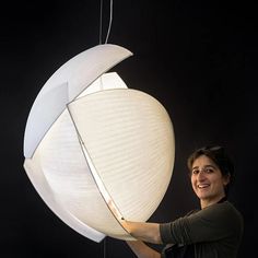 a woman is holding a large lamp in front of her face and smiling at the camera