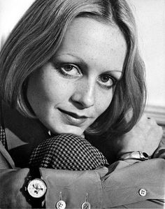 black and white photograph of a woman in trench coat with buttons on her lapel