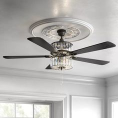 a ceiling fan in a white room with chandelier hanging from it's center