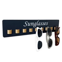 three pairs of sunglasses are hanging on a sungglass holder that says, sun glasses