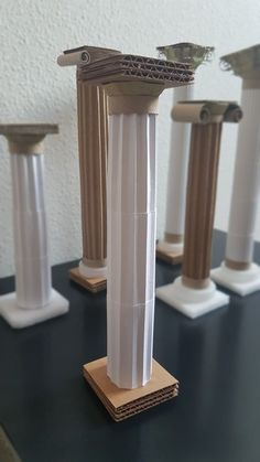 four white and brown pedestals on top of a black table next to each other