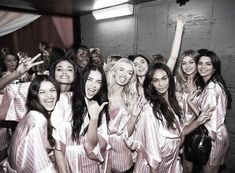 a group of women standing next to each other posing for a photo in front of a mirror