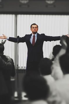 a man standing in front of a microphone with his arms outstretched