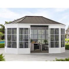 a white gazebo sitting on top of a patio next to a pool