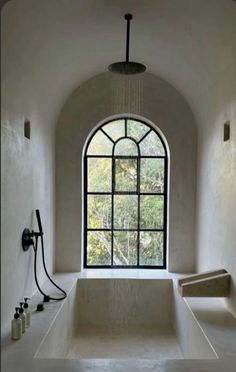 a large bath tub sitting under a window next to a faucet and shower head