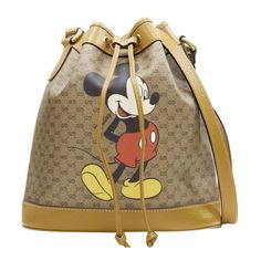 GUCCI DISNEY Candy GG Micky Mouse brown leather trim bucket bag Reference: TGAS/E00087 Brand: Gucci Designer: Alessandro Michele Model: Candy GG Collection: Disney Material: Canvas, Leather Color: Brown Pattern: Disney Closure: Drawstring Lining: Fabric Extra Details: Candy GG Bucket bag. Brown vintage GG monogram canvas. Brown genuine leather trim. Antique gold-tone hardware. Drawstring front. Adjustable shoulder strap. Made in: Italy CONDITION: Condition: Excellent, this item was pre-owned and is in excellent condition. Comes with: Designer tags. One dust bag. MEASUREMENTS: Width (width across base): 27cm / 10.5" Height (base to opening): 27cm / 10.5" Depth (side depth): 13cm / 5.1" Strap drop: 58cm / 22.6" This Gucci item is authentic. Disney Candy, Bag Reference, Gg Collection, Gucci Clutch, Gucci Outfits, Beaded Evening Bags, Gucci Designer, Gucci Tote, Evening Clutch Bag