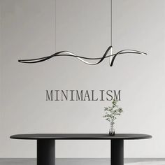 the minimalism logo is displayed on a wall above a table with a plant in it