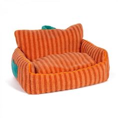 an orange and green striped dog bed on a white background with a blue stripe pillow