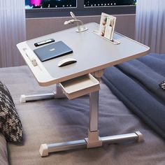 a laptop computer sitting on top of a white desk next to a window with city lights in the background