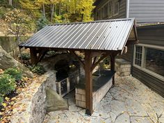 an outdoor bbq in the middle of a yard with fall leaves on the ground