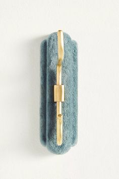 a blue towel hanging on the wall with a gold ring around it's edge