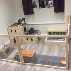 an indoor play area with toys and other items on the floor in front of a window