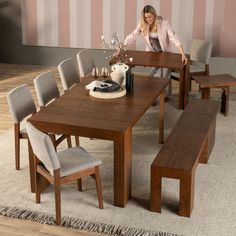 a woman sitting at a wooden dining table