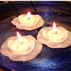 three lit candles sitting on top of a blue plate