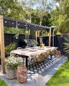 an outdoor dining area with table, chairs and potted plants