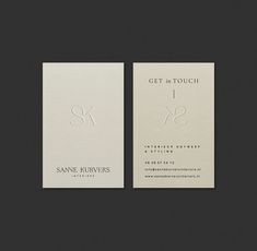 two business cards with scissors on the front and back, both printed in white paper