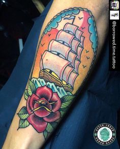 a colorful tattoo with a ship and rose on the left side of the arm is shown