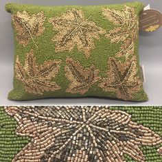 a green and gold beaded pillow with an image of leaves on the front, and side by side