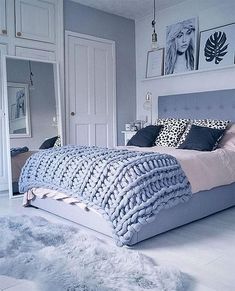 a bedroom with a bed, rugs and pictures on the wall above it's headboard