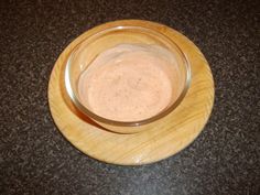 a wooden bowl filled with sauce on top of a table