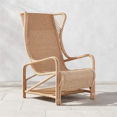 a chair made out of wicker sitting on top of a tile floor next to a wall