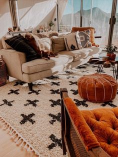 a living room filled with lots of furniture and decor on top of a white rug