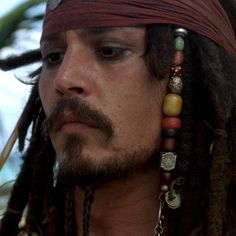 a close up of a person with dreadlocks on his head and eye makeup