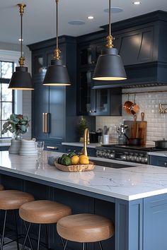 a kitchen island with stools in front of it and lights hanging from the ceiling