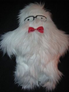 a close up of a stuffed animal with glasses and a bow tie