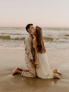 a man and woman kissing on the beach