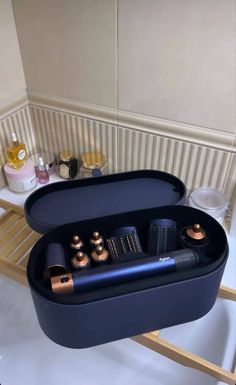 a black tray with various items in it on a white counter next to a sink