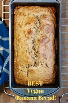 a loaf of bread sitting in a pan on top of a table next to a blue towel