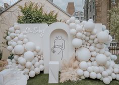 an outdoor display with white balloons and decorations