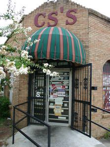 an old brick building with a green and white awning on the entrance to it