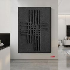 a large black piece of art hanging on the side of a wall in a living room