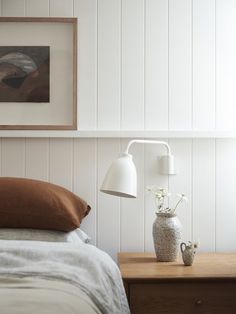 a bedroom with white walls and wood paneling