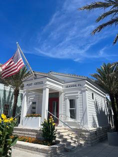 a small white building with an american flag on the roof and stairs leading up to it