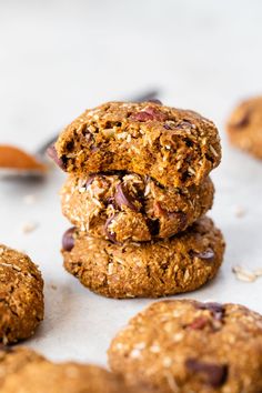 three cookies stacked on top of each other next to a cookie knife and some oatmeal