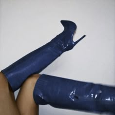 a woman's legs wearing blue high heeled boots with heels on the toes