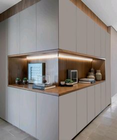 a kitchen with white cupboards and wooden counter tops, along with other items on the shelves