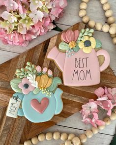 decorated cookies with the words best mom on them and flowers in vases next to it