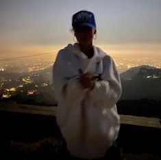 a woman standing on top of a hill at night