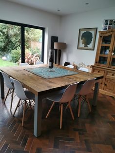 a dining room table with chairs and a large glass door leading to the back yard