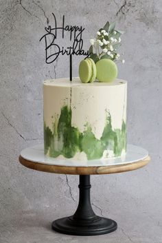 a white cake with green sprinkles and a happy birthday sign on top