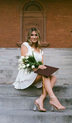 a woman sitting on steps holding a bouquet of flowers