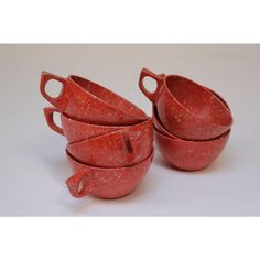 four red bowls are stacked on top of each other