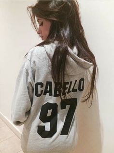 a girl with long hair standing in front of a wall wearing a sweatshirt that says carrezo 91