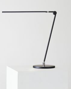 a black table lamp sitting on top of a white block