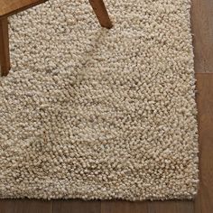 a wooden chair sitting on top of a carpet covered floor next to a white rug