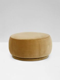 a small round ottoman sitting on top of a white table